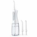 White cordless water flosser with nozzle tips on a white background